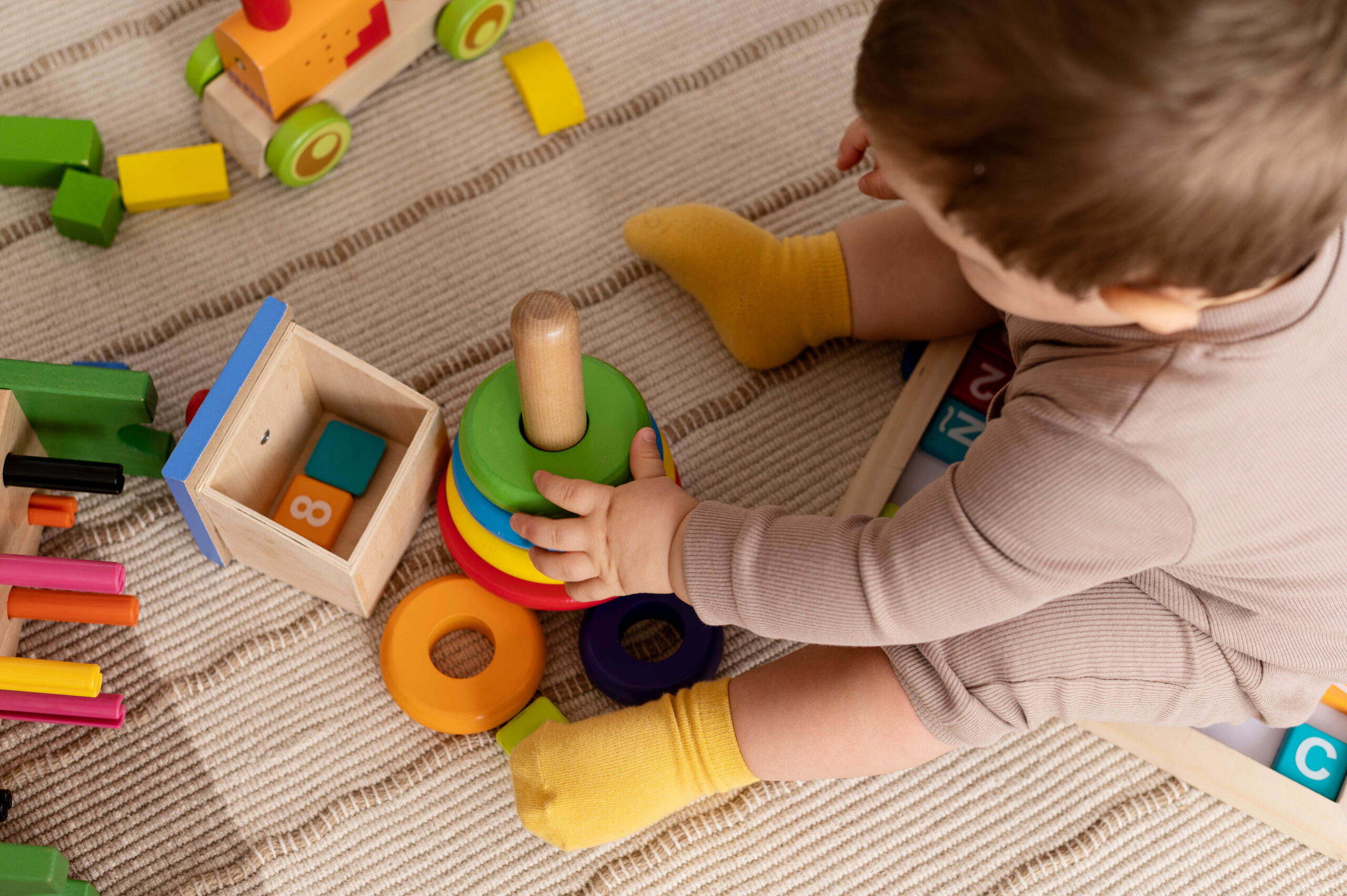 high-angle-kid-playing-with-colorful-toys